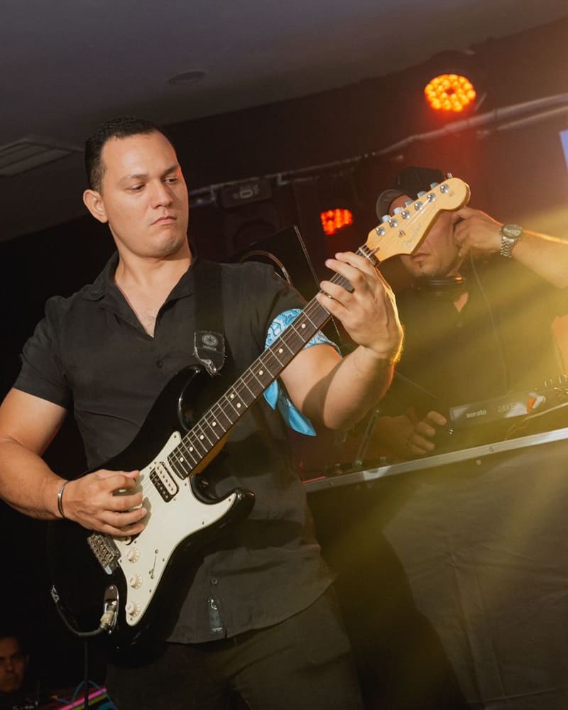 Daniel Puccini tocando guitarra eléctrica en una fiesta